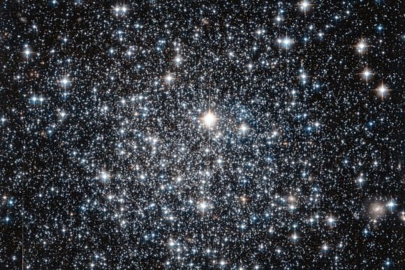 This new NASA/ESA Hubble Space Telescope image shows the globular cluster IC 4499. Globular clusters are big balls of old stars that orbit around their host galaxy. It has long been believed that all the stars within a globular cluster form at the about same time, a property which can be used to determine the cluster's age. For more massive globulars however, detailed observations have shown that this is not entirely true — there is evidence that they instead consist of multiple populations of stars born at different times. One of the driving forces behind this behaviour is thought to be gravity: more massive globulars manage to grab more gas and dust, which can then be transformed into new stars. IC 4499 is a somewhat special case. Its mass lies somewhere between low-mass globulars, which show a single generation build-up, and the more complex and massive globulars which can contain more than one generation of stars. By studying objects like IC 4499 astronomers can therefore explore how mass affects a cluster's contents. Astronomers found no sign of multiple generations of stars in IC 4499 — supporting the idea that less massive clusters in general only consist of a single stellar generation. Hubble observations of IC 4499 have also helped to pinpoint the cluster's age: observations of this cluster from the 1990s suggested a puzzlingly young age when compared to other globular clusters within the Milky Way. However, since those first estimates new Hubble data been obtained, and it has been found to be much more likely that IC 4499 is actually roughly the same age as other Milky Way clusters at approximately 12 billion years old. Credit: ESA/NASA/HST