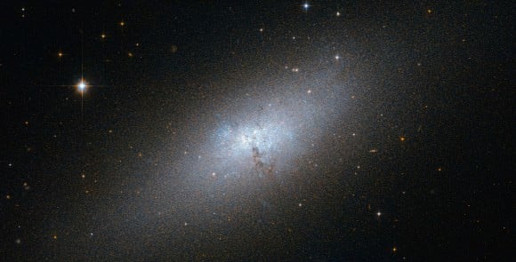 NGC 5253 is one of the nearest of the known Blue Compact Dwarf (BCD) galaxies, and is located at a distance of about 12 million light-years from Earth in the southern constellation of Centaurus. It is experiencing a starburst of hot, young stars, which could be caused by dark satellites. Image: NASA/ESA/Hubble.