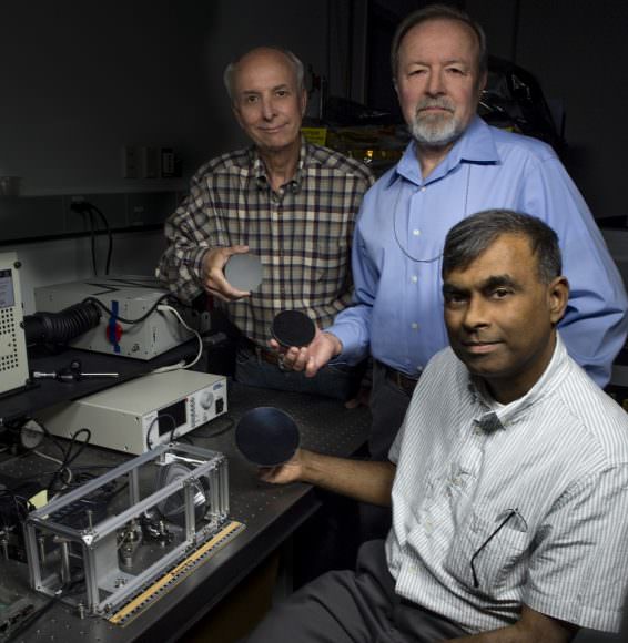 John Kolasinski (left), Ted Kostiuk (center), and Tilak Hewagama (right) hold mirrors made of carbon nanotubes in an epoxy resin. The mirror is being tested for potential use in a lightweight telescope specifically for CubeSat scientific investigations. Credits: NASA/W. Hrybyk