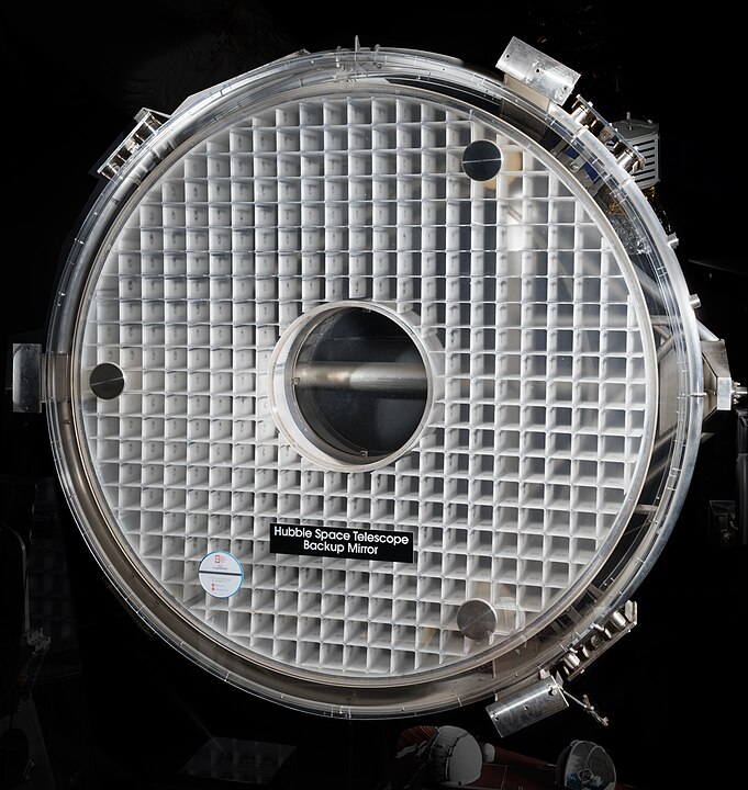 This picture of the un-coated backup primary mirror for the Hubble Space Telescope shows its honeycomb structure. Image Credit: By Eric Long for Smithsonian Institution - https://airandspace.si.edu/multimedia-gallery/a20010288000nasm2017-10014jpg, CC0, https://commons.wikimedia.org/w/index.php?curid=136364120