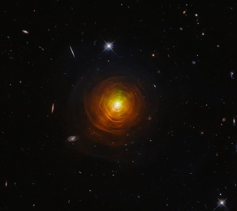 CW Leonis, not a part of this study, glowers from deep within a thick shroud of dust in this image from the NASA/ESA Hubble Space Telescope. Lying roughly 400 light-years from Earth in the constellation Leo, CW Leonis is a carbon star — a luminous type of red giant star with a carbon-rich atmosphere. The dense clouds of sooty gas and dust engulfing this dying star were created as the outer layers of CW Leonis itself were thrown out into the void. Image Credit: ESA/Hubble & NASA, T. Ueta, H. Kim