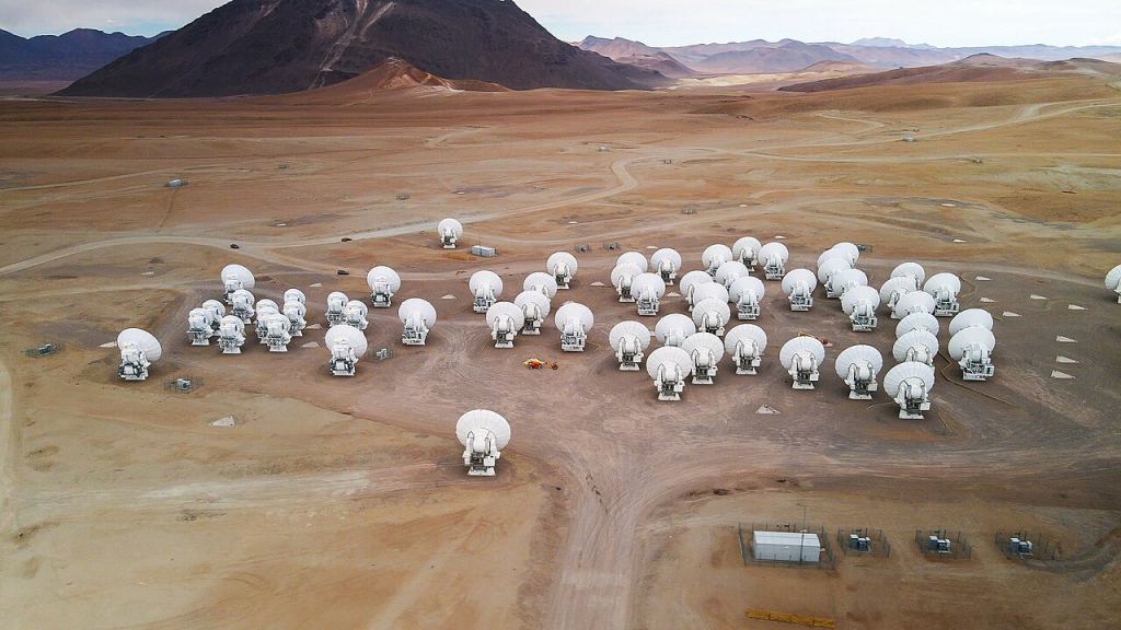Image showing the ALMA site from above with multiple radio receivers.