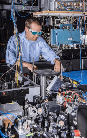 Physicists at the National Institute of Standards and Technology (NIST) have developed an atomic clock based on the element ytterbium that has broken performance benchmarks for atomic clocks. Physicist Andrew Ludlow pictured. Image Credit: Burrus/NIST