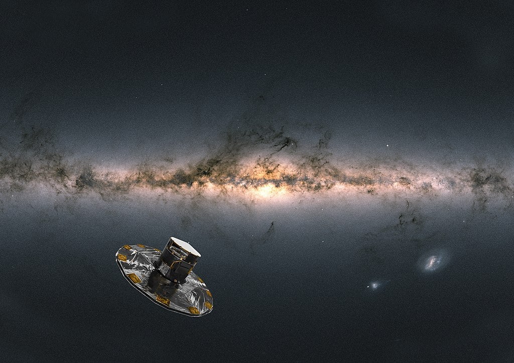 Artist impression of ESA's Gaia satellite observing the Milky Way. The background image of the sky is compiled from data from more than 1.8 billion stars. It shows the total brightness and colour of stars observed by Gaia