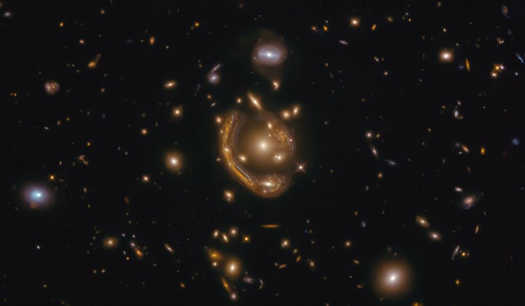 The narrow galaxy elegantly curving around its spherical companion in this image is a fantastic example of a truly strange and very rare phenomenon. This image, taken with the NASA/ESA Hubble Space Telescope, depicts GAL-CLUS-022058s, located in the southern hemisphere constellation of Fornax (The Furnace). GAL-CLUS-022058s is the largest and one of the most complete Einstein rings ever discovered in our Universe. The object has been nicknamed by the Principal Investigator and his team who are studying this Einstein ring as the