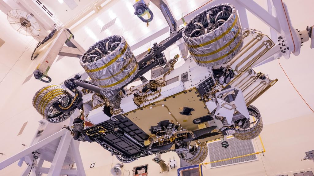 In this image the Ingenuity helicopter can be seen attached to the underside of the Perseverance rover.