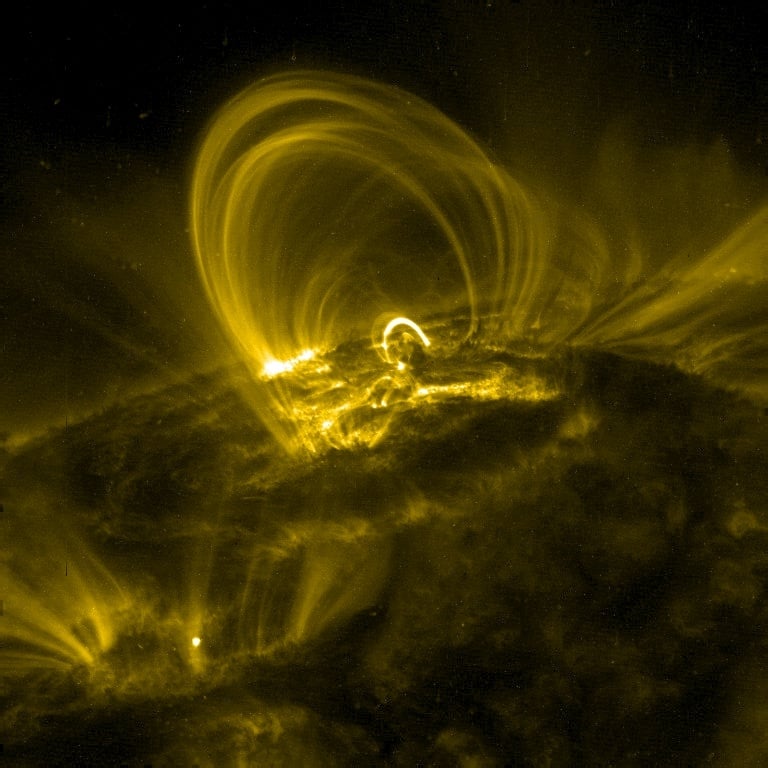 This image is an example of solar coronal loops observed by the Transition Region And Coronal Explorer (TRACE). These loops have a temperature of approximately 106 K. These loops contrast greatly with the cool chromosphere below. Image Credit: By NASA Public Domain