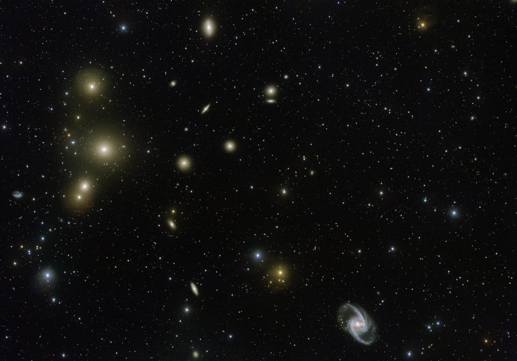 The Fornax Galaxy Cluster is one of the closest of such groupings beyond our Local Group of galaxies. This new VLT Survey Telescope image shows the central part of the cluster in great detail. At the lower-right is the elegant barred-spiral galaxy NGC 1365 and to the left the big elliptical NGC 1399. Image Credit: By ESO. Acknowledgement: Aniello Grado and Luca Limatola - http://www.eso.org/public/images/eso1612a/, CC BY 4.0, https://commons.wikimedia.org/w/index.php?curid=48164737
