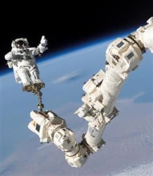 Canadarm2, the huge robotic arm on the International Space Station holds astronaut Stephen Robinson during the STS-114 mission. Credit: NASA