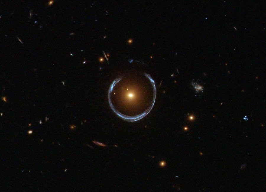 Hubble image of a luminous red galaxy (LRG) gravitationally distorting the light from a much more distant blue galaxy, a technique known as gravitational lensing. Credit: ESA/Hubble & NASA