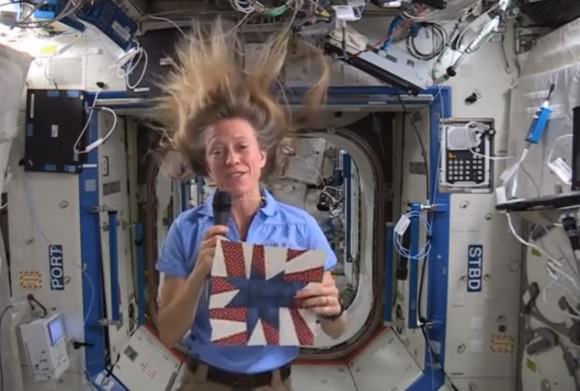 NASA astronaut Karen Nyberg holds a quilt patch that she made in space during Expedition 36/37 in 2013. Nyberg is inviting quilters to submit star-themed patches of their own for a quilt to display at the International Quilt Festival in Houston in 2014. Credit: NASA (YouTube/screenshot)