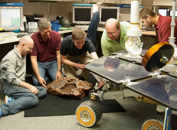Researcher Kris Capraro (second from left) adds the finishing touches of realistic color to a model of the "Block Island" meteorite.Credit: NASA/JPL-Caltech