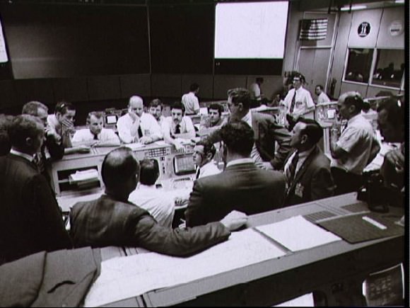 Overall view showing some of the activity in the Mission Operations Control Room during the final 24 hours of the Apollo 13 mission. From left to right are Shift 4 Flight Director Glynn Lunney, Shift 2 Flight Director Gerald Griffin, Astronaut and Apollo Spacecraft Program Manager James McDivitt, Director of Flight Crew Operations Deke Slayton and Shift 1 Flight Surgeon Dr. Willard Hawkins. Credit: NASA.