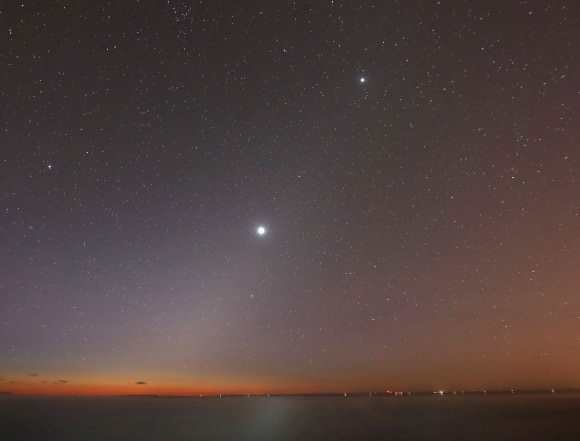 Venus glares inside the cone of the zodiacal light this morning at the start of astronomical twilight over the shoreline of northern Wisconsin. Jupiter is seen at top and Mars two-thirds of the way from Jupiter to Venus. Credit: Bob King