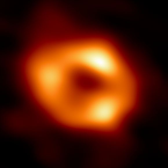 This is the first image of Sgr A*, the supermassive black hole at the center of our galaxy. A reanalysis of EHT data by NAOJ scientists suggests its accretion disk may be more elongated than shown in this image.  Image Credit: EHT