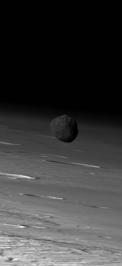 This is the original image from the High-Resolution Stereo Camera (HRSC) on ESA's Mars Express spacecraft. It caught Phobos over Mars' limb on March 26, 2010. The waviness of Mars in the background is a by-product of HRSC's line-scanning operation. Image Credit: ESA / DLR / FU Berlin (G. Neukum)