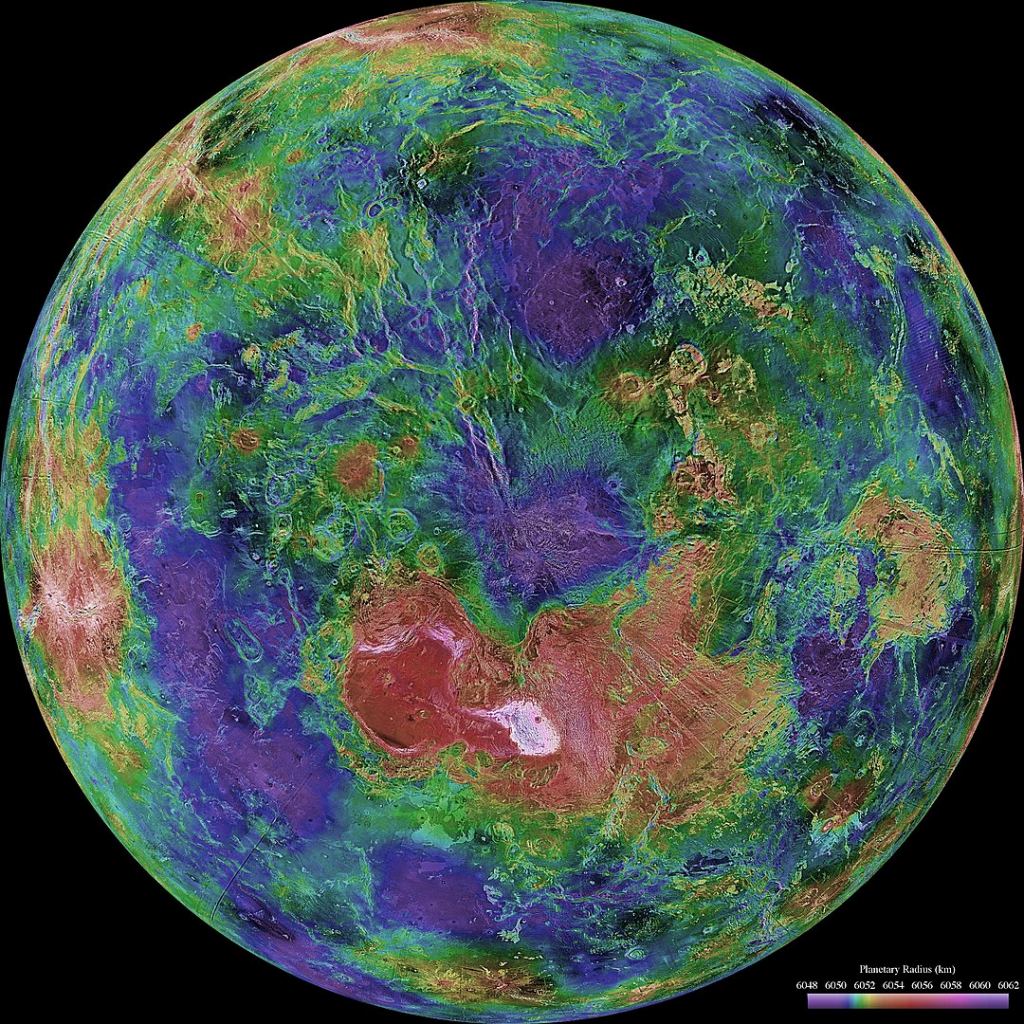 This view of Venus is centred on its north pole. Ishtar Terra is the red region just below the image's centre. The white region is Maxwell Montes, and the left-most red lobe is Lakshmi Planum. Image Credit: NASA/JPL/USGS - http://photojournal.jpl.nasa.gov/catalog/PIA00007, Public Domain, https://commons.wikimedia.org/w/index.php?curid=18235544