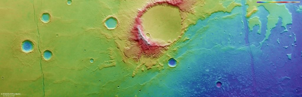 Red is high elevation, and blue is low elevation. The lakebed boundaries curve up and away from the bottom centre of the frame towards the top right, skirting around the large central crater. This is one of several lakebeds in the region that were once joined into one vast lake named Lake Eridania. Image Credit: ESA/DLR/FU Berlin. Licence: CC BY-SA 3.0 IGO or ESA Standard Licence